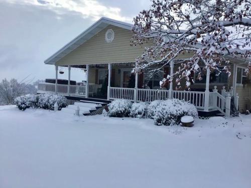 a house with snow on the ground in front of it at The Lookout House at The Bluebird in Eureka Springs