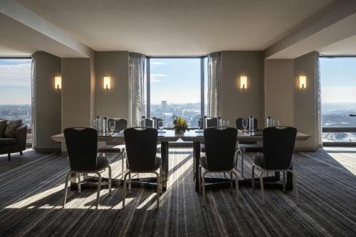 a dining room with a table and chairs and large windows at Kansas City Marriott Downtown in Kansas City