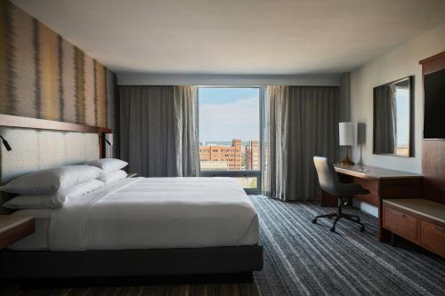 a hotel room with a bed and a desk and a window at Kansas City Marriott Downtown in Kansas City