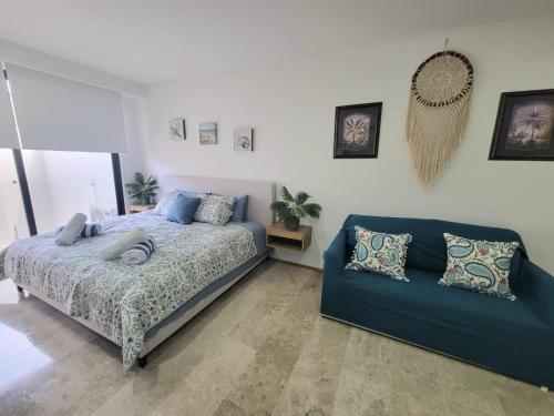 a bedroom with a bed and a couch at Live Playa Beach, Luxury & 5th Av at your doorstep in Playa del Carmen