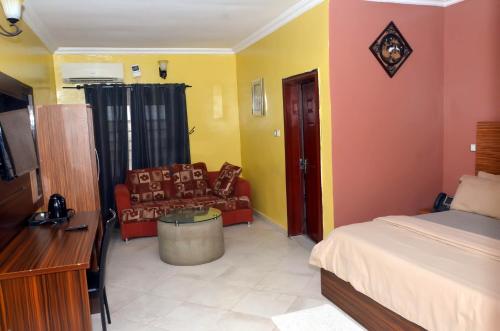 a hotel room with a bed and a couch at Romeo Suites & Apartment in Ipaja