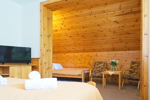 a bedroom with two beds and a flat screen tv at Hotel Horník in Žďár nad Sázavou