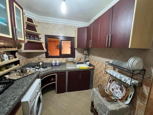 une cuisine avec des armoires marron et un comptoir dans l'établissement Mini-villa Imiouadar vue mer , grand confort, à Agadir