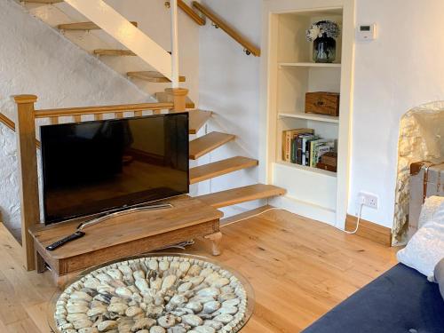 a living room with a flat screen tv and stairs at Fisherman's Cottage in Plymouth