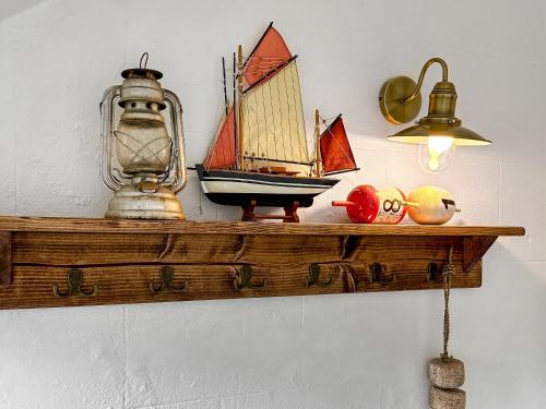 a wooden shelf with a toy sail boat on it at The Gables in Gorran Haven