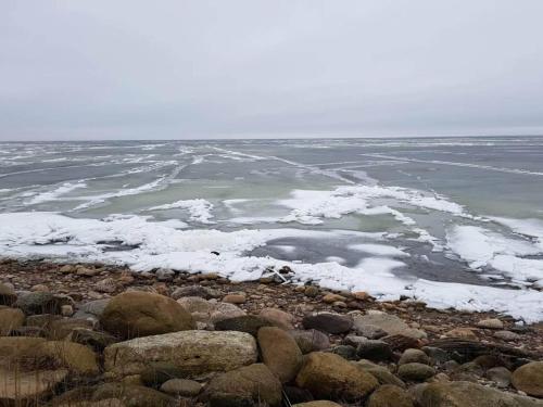 a large body of water with snow on the rocks at Charming Retreat in Ringkobing - By Traum Ferienwohnungen in Ringkøbing