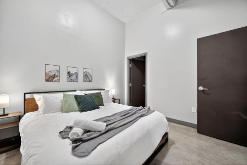 Un dormitorio con una cama blanca con toallas. en Stunning Downtown Apartment with Pool, Laundry, Parking, en Dallas