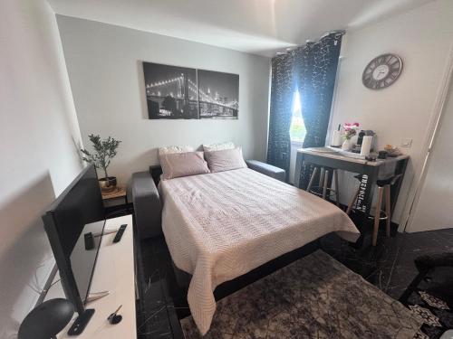 a small bedroom with a bed and a desk at Appartement 2 pièces à Rosny-sous-Bois à quelques pas du Métro in Rosny-sous-Bois