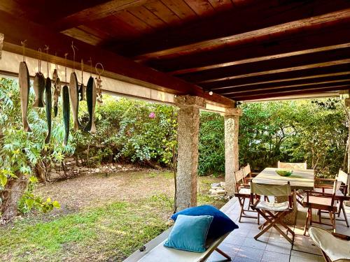 a patio with a table and chairs and surfboards on it at Adoro San Teodoro - rooms in San Teodoro