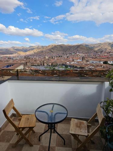 a table and two chairs on a balcony with a view at Hostal Casa Del Inka in Cusco