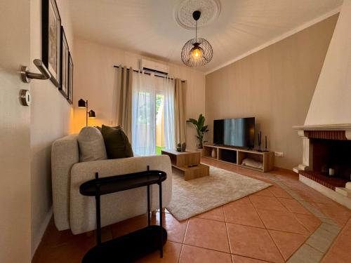 a living room with a couch and a television at Cosy 1-Bedroom Apartment with Private Terrace in Loulé in Loulé
