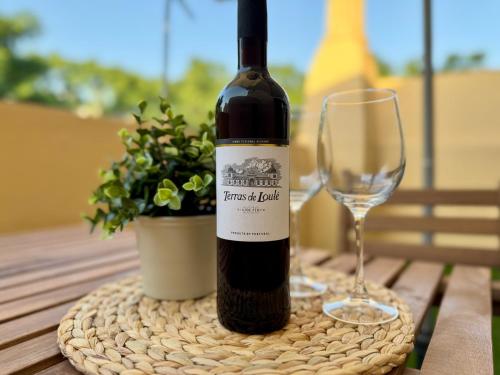 a bottle of wine and a glass on a table at Cosy 1-Bedroom Apartment with Private Terrace in Loulé in Loulé
