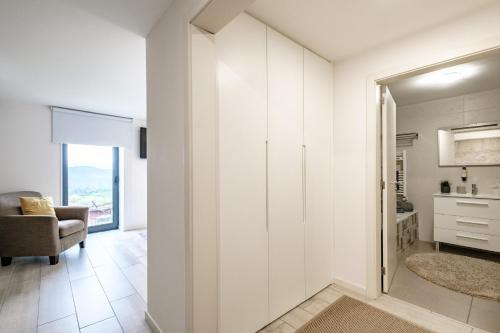 a living room with white cabinets and a chair at Casa do Barroso - Casa Mãe in Cabeceiras de Basto