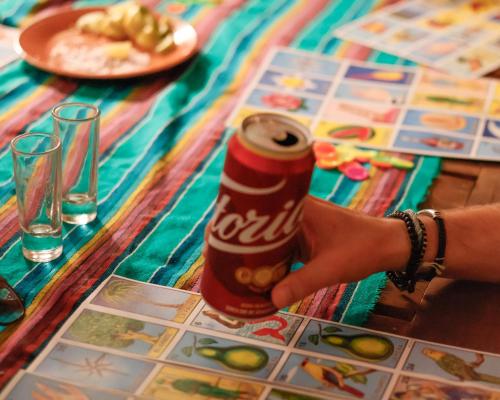 a person holding a can of cocacola on a table at El Pinche Hostal in Guadalajara