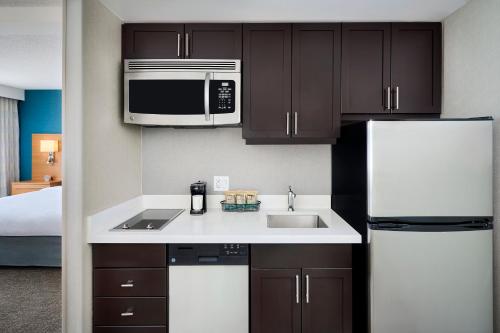 a kitchen with a sink and a microwave and a refrigerator at TownePlace Suites by Marriott Mississauga-Airport Corporate Centre in Mississauga
