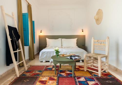 a bedroom with a bed and a table and a chair at Riad Chamali in Marrakesh