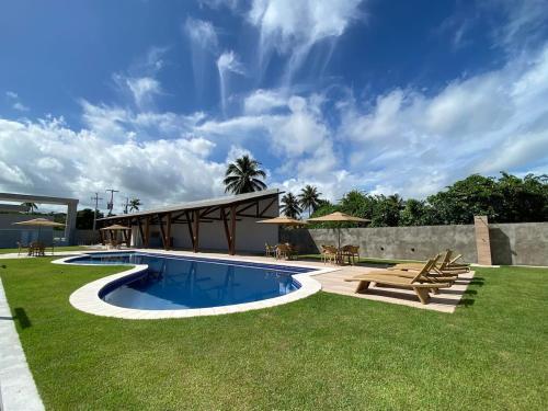 einen Hinterhof mit einem Pool und einem Picknicktisch in der Unterkunft Casa de alto padrão em Maragogi - Alagoas in Maragogi