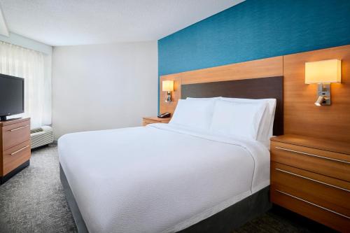 a bedroom with a large white bed and a tv at TownePlace Suites by Marriott Mississauga-Airport Corporate Centre in Mississauga