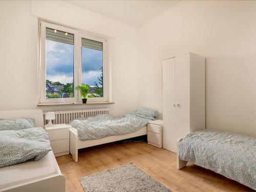a white room with two beds and a window at Breite Str 154 Selm in Selm
