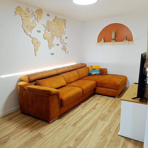 a brown couch in a living room with a world map on the wall at SUPERTUBOS HOUSE Peniche in Peniche