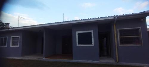 a blue building with a door and a window at Kitnet Sossego na Praia (Caraguatatuba/Massaguaçu) in Caraguatatuba