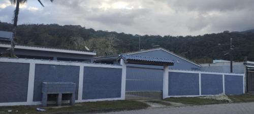 a blue and white fence with a bench in front of a building at Kitnet Sossego na Praia (Caraguatatuba/Massaguaçu) in Caraguatatuba