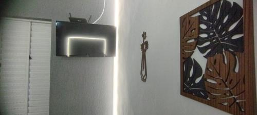 a mirror hanging on a wall with a butterfly picture at Kitnet Sossego na Praia (Caraguatatuba/Massaguaçu) in Caraguatatuba