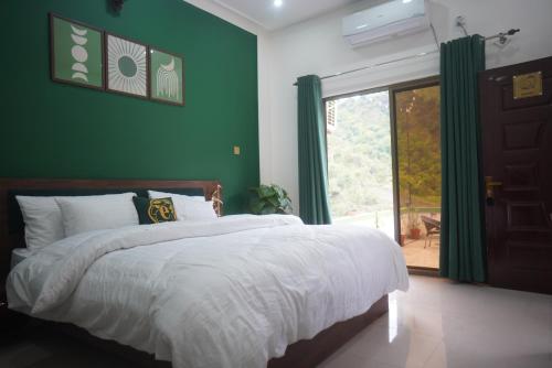 a green bedroom with a bed and a large window at Escaven - Your escape to Heaven 
