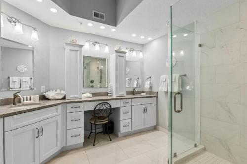 un bagno con due lavandini e una doccia in vetro di 60 Ocean Place a Fernandina Beach