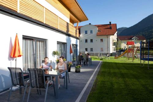 弗拉绍Apartments in Flachau - Salzburger Land 368的两名妇女坐在天井的桌子上