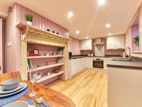 a kitchen with a wooden table and a dining room at Alt-Na-Craig in Rothbury