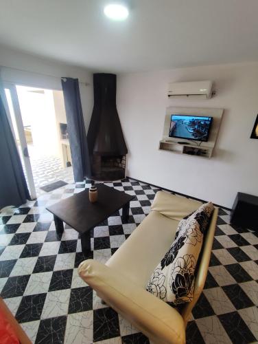a living room with a couch and a tv at Arenas del Diablo in Punta Del Diablo