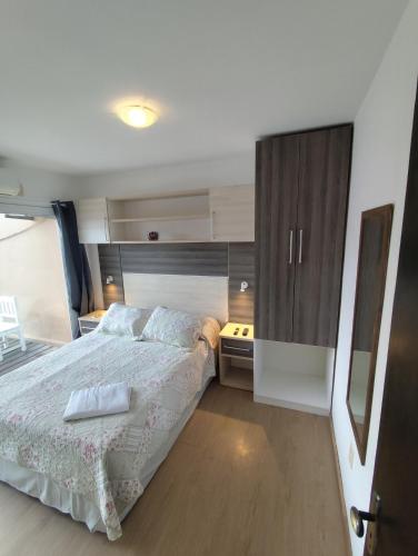a bedroom with a large bed and a kitchen at Arenas del Diablo in Punta Del Diablo