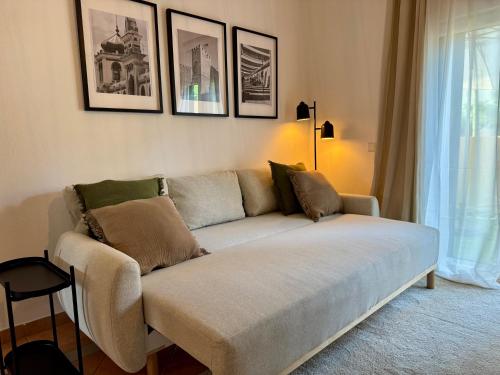 a couch in a living room with pictures on the wall at Cosy 1-Bedroom Apartment with Private Terrace in Loulé in Loulé