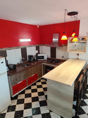 a kitchen with red walls and a wooden counter top at Arenas del Diablo in Punta Del Diablo