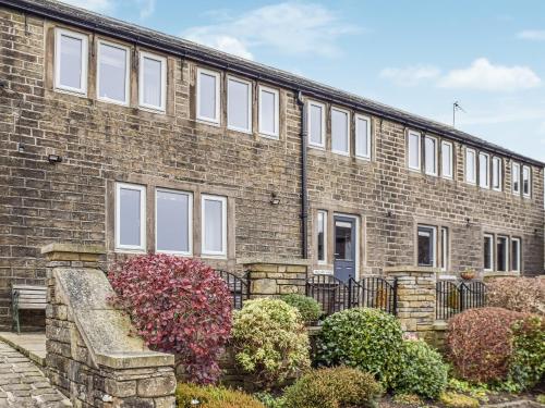a brick building with bushes in front of it at Trough Cottage - Uk48424 in Holmfirth