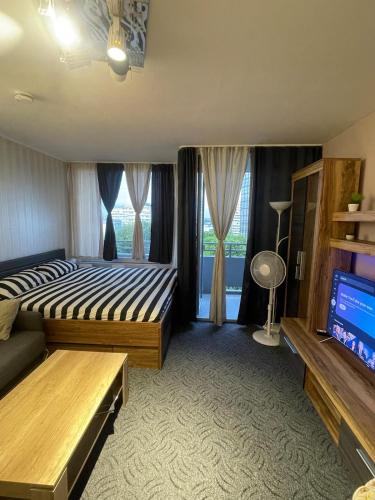a bedroom with a bed and a tv in a room at Panorama building in Eschborn