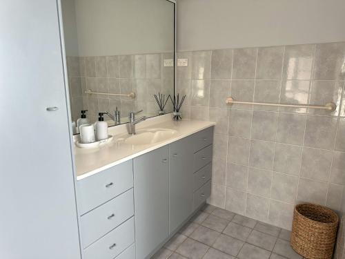 a bathroom with a sink and a shower at Whitecaps Beachhouse - Pet Friendly on Easts Beach - Book 3 nights, pay 2 in Kiama