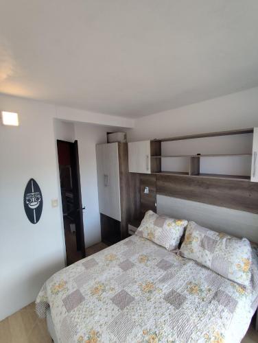 a bedroom with a bed with a wooden headboard at Arenas del Diablo in Punta Del Diablo