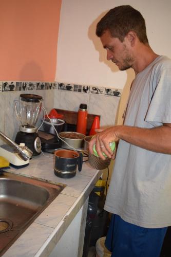 a man standing in a kitchen holding a bowl at Manantial de Vida in Cuispes
