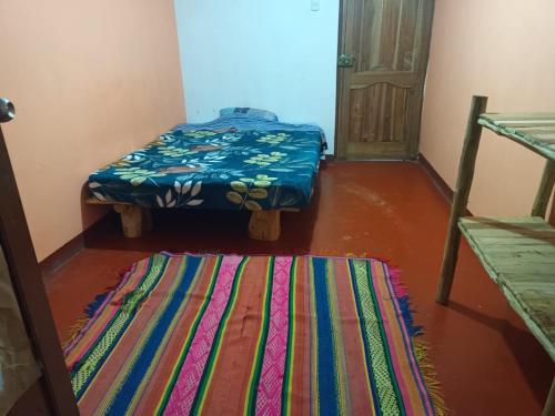 a room with two beds and a rug on the floor at Manantial de Vida in Cuispes