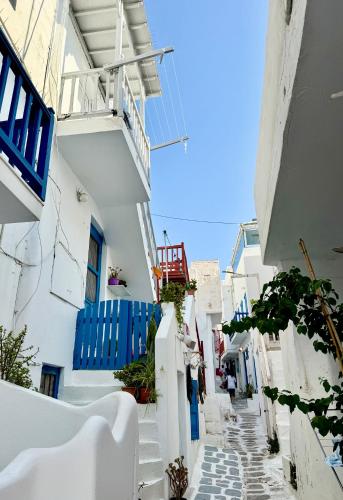 ミコノス・シティにあるSilverWave Mykonosの白い建物と青い門のある狭い路地