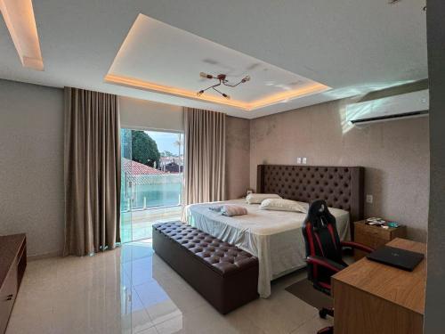 a bedroom with a bed and a couch and a window at Casa em condomínio para COP 30 in Belém