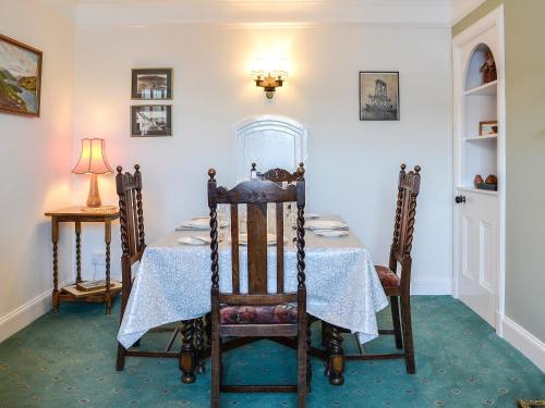 a dining room with a table and chairs and a lamp at St Enodoc in Ullapool
