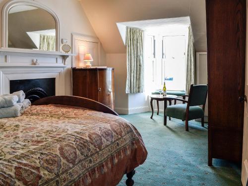 a bedroom with a bed and a chair and a desk at St Enodoc in Ullapool