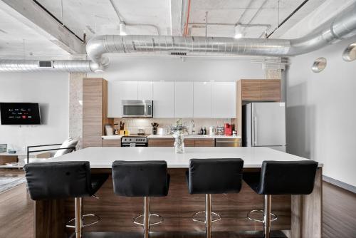 a kitchen with a large white table and black chairs at Stunning Downtown Apartment with Pool, Laundry, Parking in Dallas