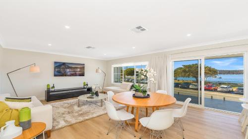 a living room with a table and chairs at Ettalong Waterfront Retreat in Ettalong Beach