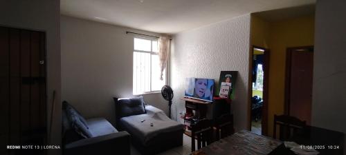 a living room with a couch and a chair and a window at Lorena in Ananindeua