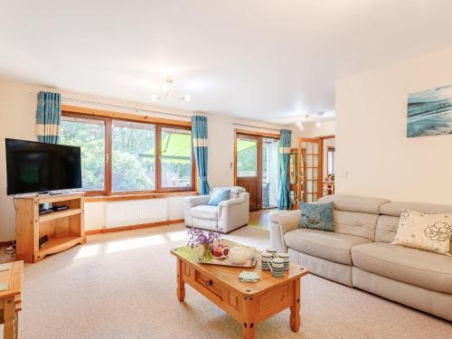 a living room with a couch and a tv at Glen View Of Enrick House in Bearnock