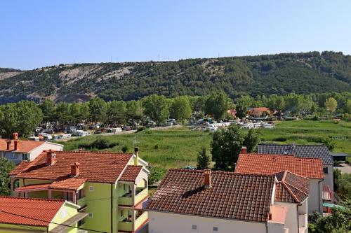 a town with houses and a mountain in the background at Apartments with parking space Lopar, Rab - 24617 in Lopar
